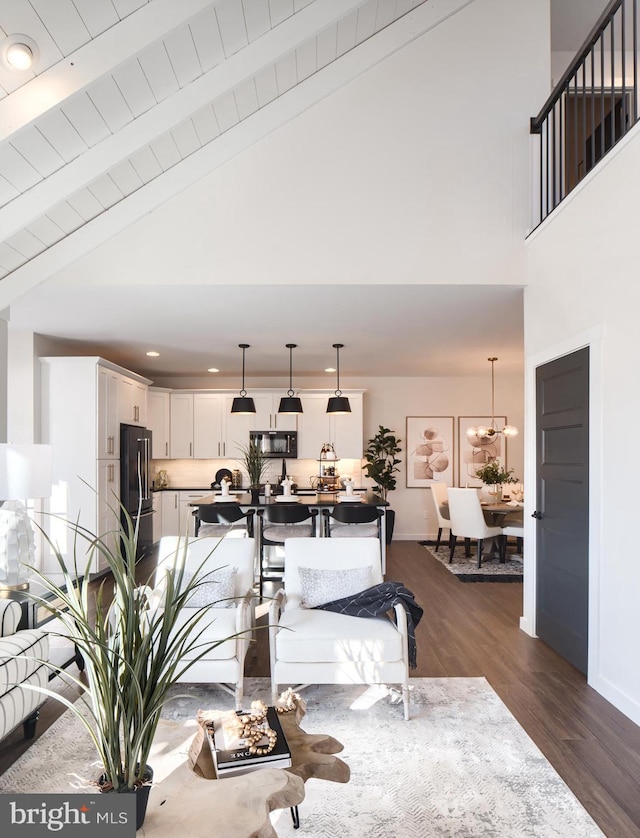 living room featuring beamed ceiling, dark hardwood / wood-style floors, high vaulted ceiling, and a notable chandelier