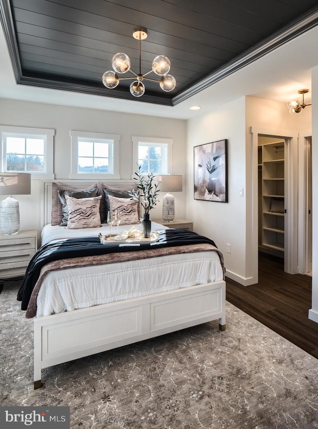 bedroom featuring wooden ceiling, dark hardwood / wood-style flooring, multiple windows, and a spacious closet