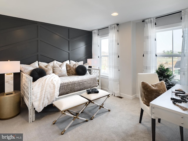 bedroom with light colored carpet and multiple windows