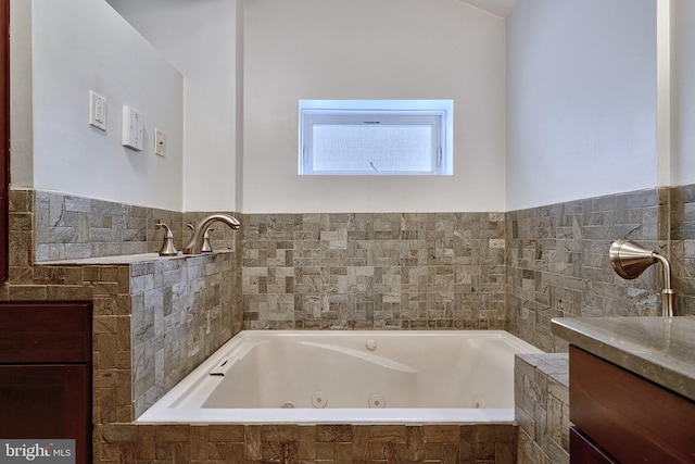 bathroom featuring vanity and a relaxing tiled tub