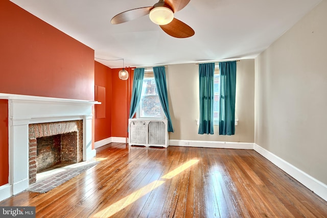 unfurnished living room featuring a fireplace, wood-type flooring, and ceiling fan