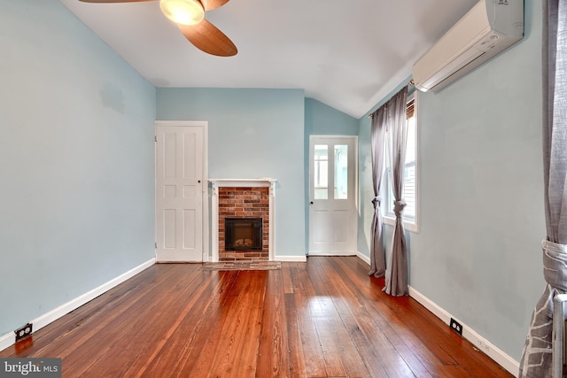 unfurnished living room with a wall mounted AC, a fireplace, dark hardwood / wood-style flooring, vaulted ceiling, and ceiling fan