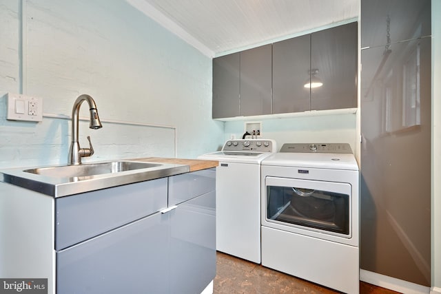 laundry area with cabinets, washer and dryer, sink, and ornamental molding