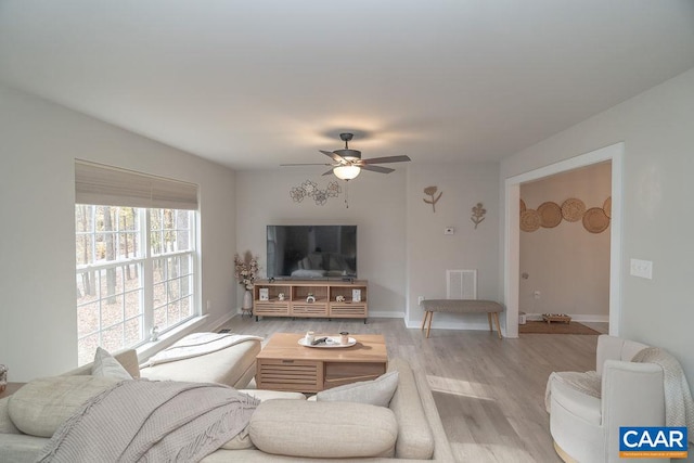 living room with ceiling fan and light hardwood / wood-style flooring