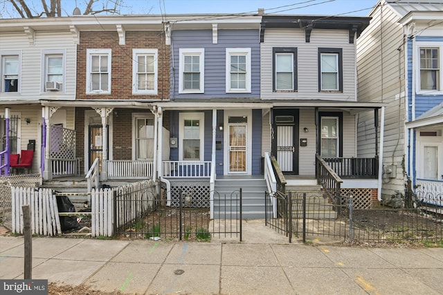 townhome / multi-family property featuring cooling unit and covered porch