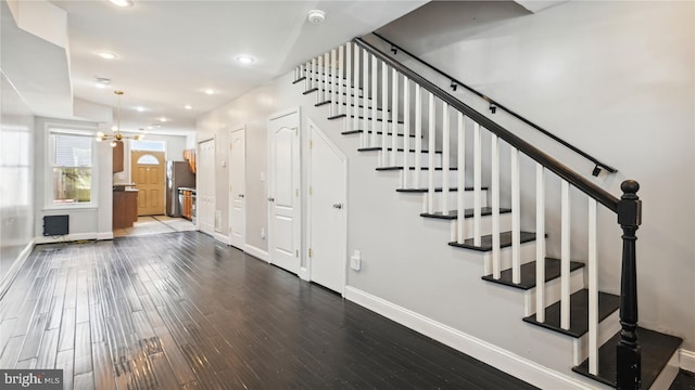 staircase featuring a chandelier and hardwood / wood-style floors