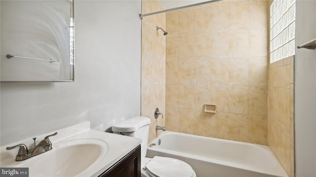 full bathroom with vanity, tiled shower / bath combo, and toilet