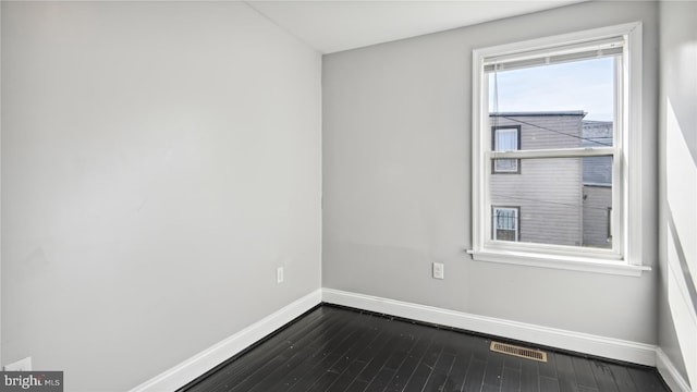 spare room with dark wood-type flooring