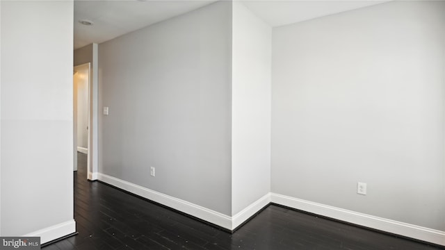 unfurnished room with dark wood-type flooring