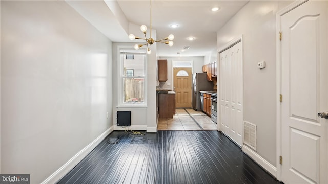 corridor featuring dark hardwood / wood-style flooring and a chandelier