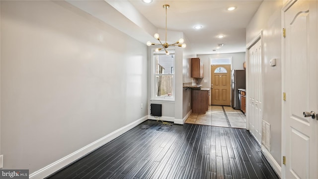 entrance foyer with light hardwood / wood-style floors and an inviting chandelier