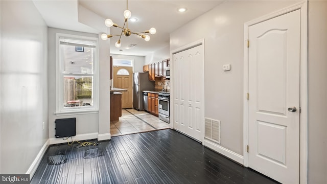 kitchen with a chandelier, appliances with stainless steel finishes, and light hardwood / wood-style floors