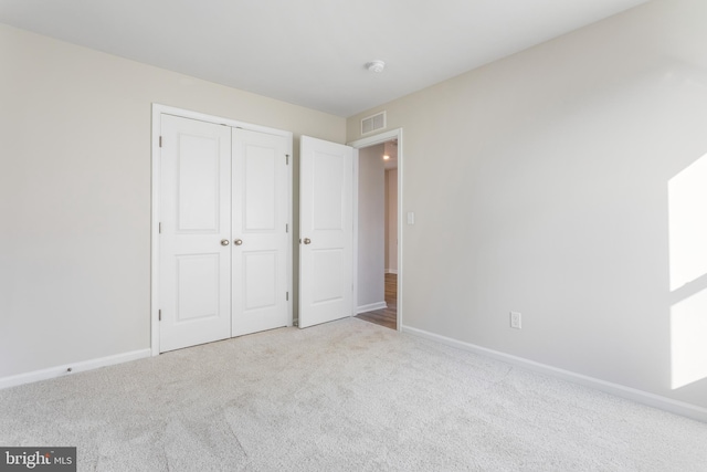 unfurnished bedroom featuring a closet and light carpet