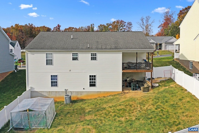 back of property with central AC and a yard