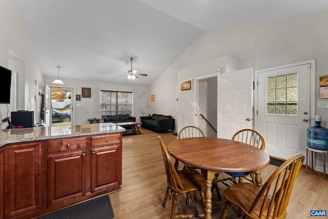 dining space featuring vaulted ceiling, ceiling fan, and light hardwood / wood-style flooring