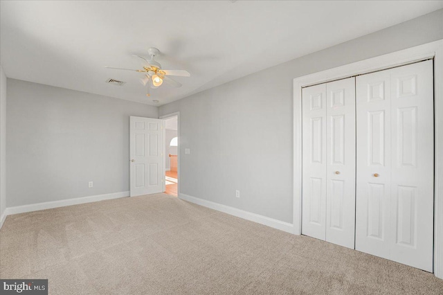 unfurnished bedroom with carpet floors, a closet, and ceiling fan