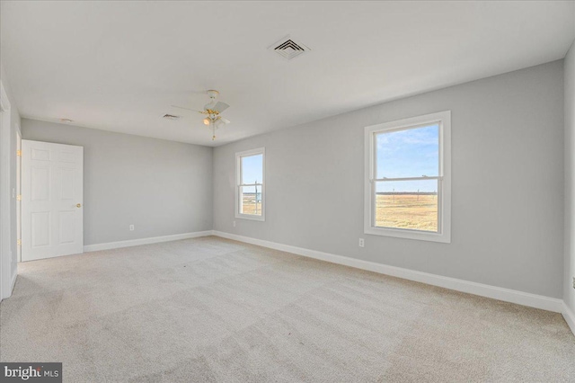 spare room featuring ceiling fan and light carpet