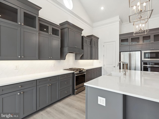 kitchen featuring appliances with stainless steel finishes, tasteful backsplash, vaulted ceiling, and hanging light fixtures