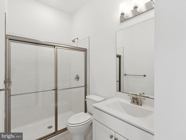 bathroom with vanity, toilet, and a shower with shower door