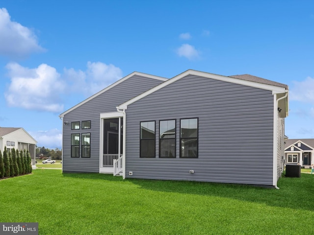 rear view of property with a lawn and central AC unit