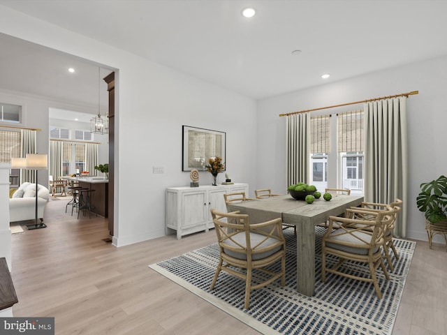 dining room with light hardwood / wood-style floors and an inviting chandelier