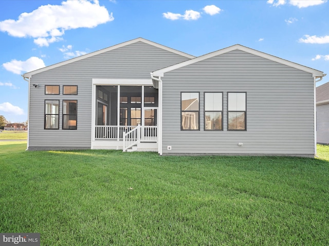 rear view of house with a sunroom and a yard