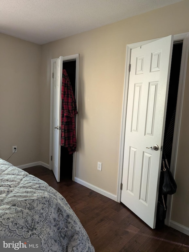 bedroom with dark wood-type flooring and a textured ceiling