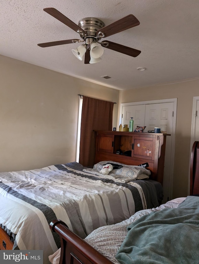 bedroom with a textured ceiling and ceiling fan