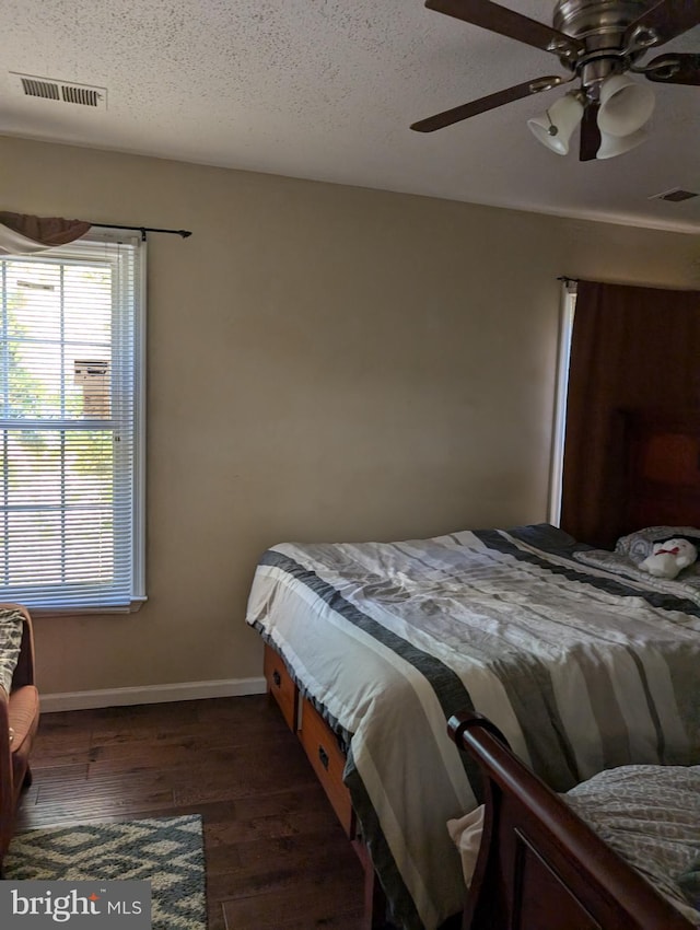 bedroom featuring a textured ceiling, dark hardwood / wood-style floors, and ceiling fan