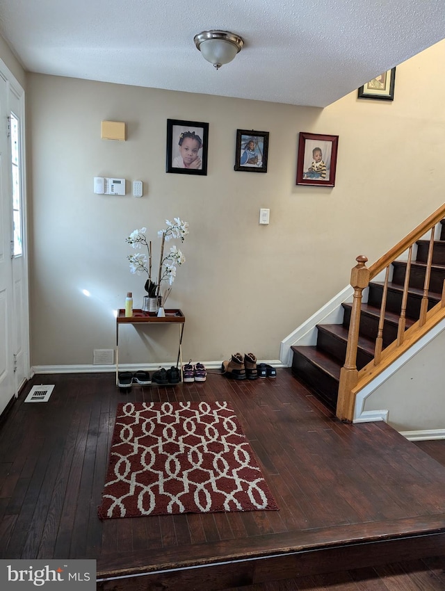 foyer with hardwood / wood-style floors and a textured ceiling