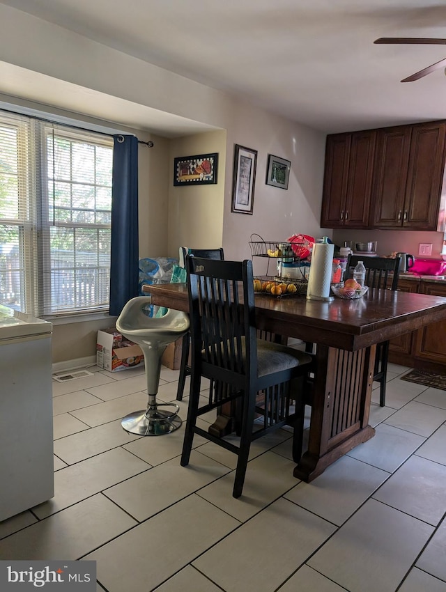 tiled dining room with ceiling fan