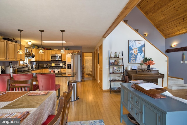 dining space featuring lofted ceiling, sink, and light hardwood / wood-style floors