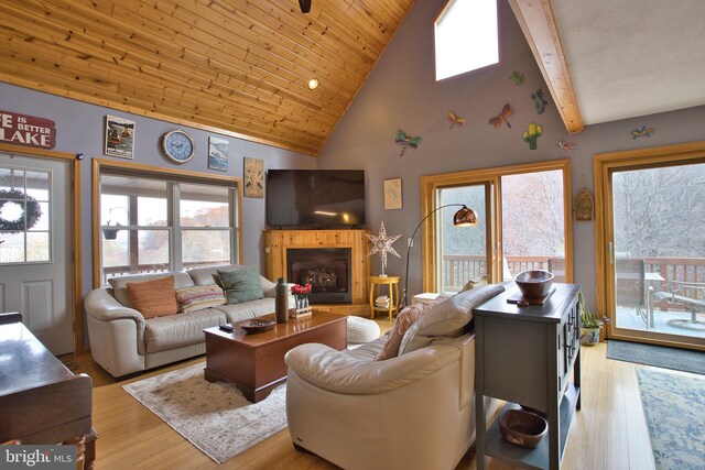 living room featuring wooden ceiling, light hardwood / wood-style floors, beamed ceiling, and high vaulted ceiling