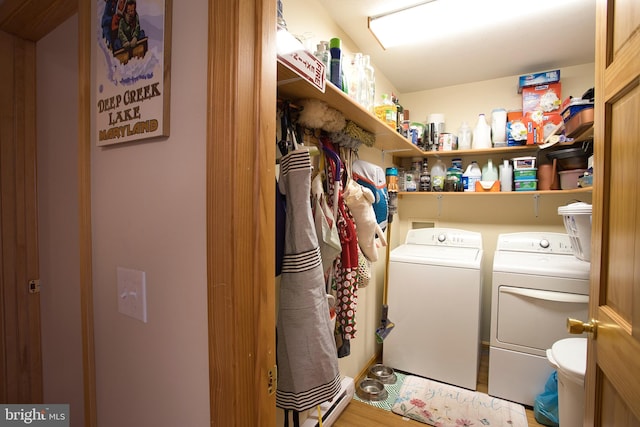 laundry area featuring washing machine and dryer, hardwood / wood-style flooring, and a baseboard radiator