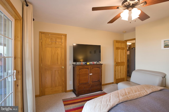 bedroom with stainless steel fridge, light carpet, and ceiling fan