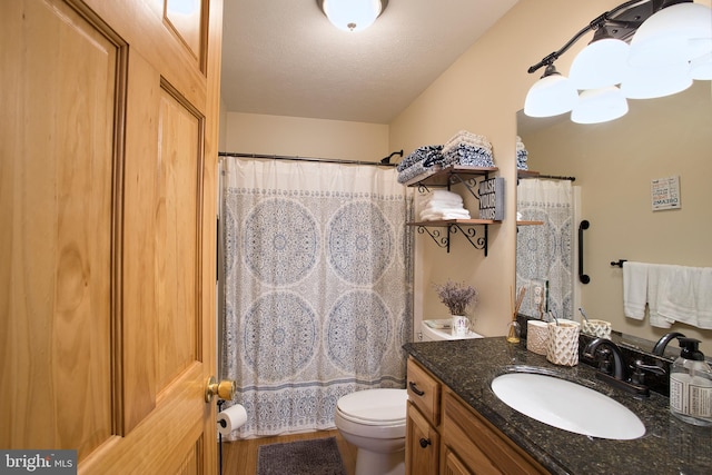 bathroom with curtained shower, vanity, toilet, and a textured ceiling