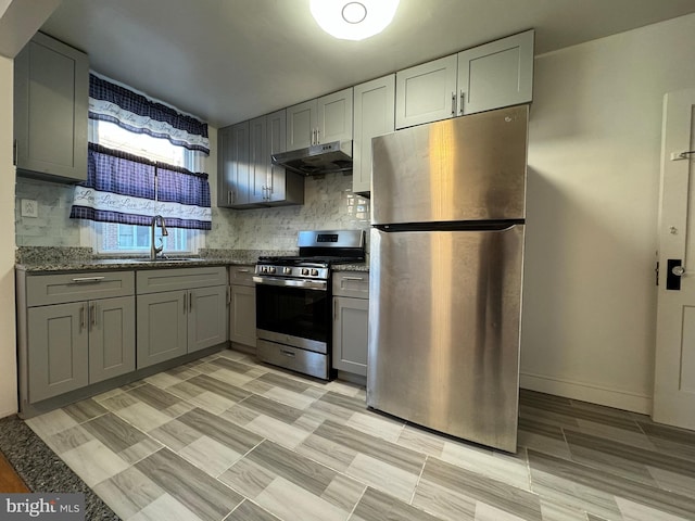 kitchen featuring gray cabinets, light stone countertops, appliances with stainless steel finishes, and sink