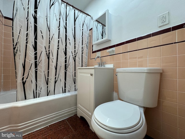 full bathroom with vanity, toilet, tile walls, and shower / tub combo