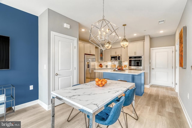 dining room featuring an inviting chandelier and light hardwood / wood-style flooring