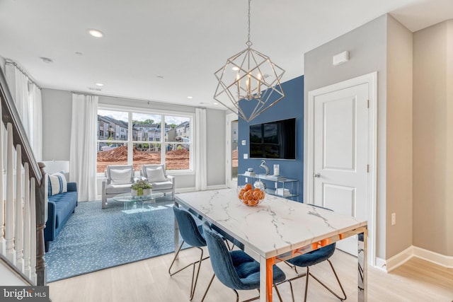 dining space with a notable chandelier and light hardwood / wood-style flooring