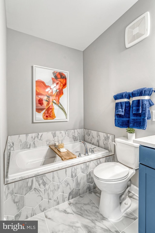 bathroom with vanity, toilet, and tiled tub