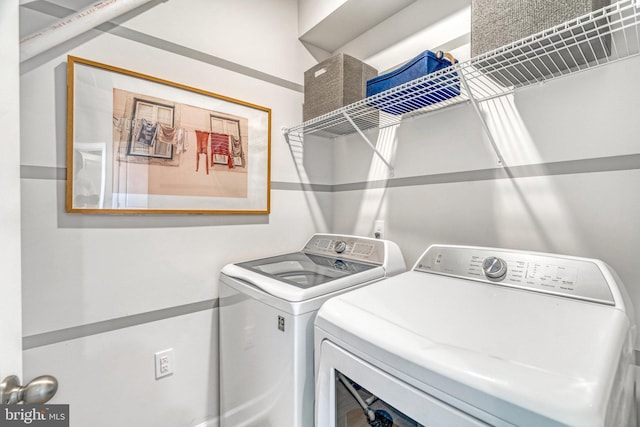 clothes washing area with washing machine and dryer