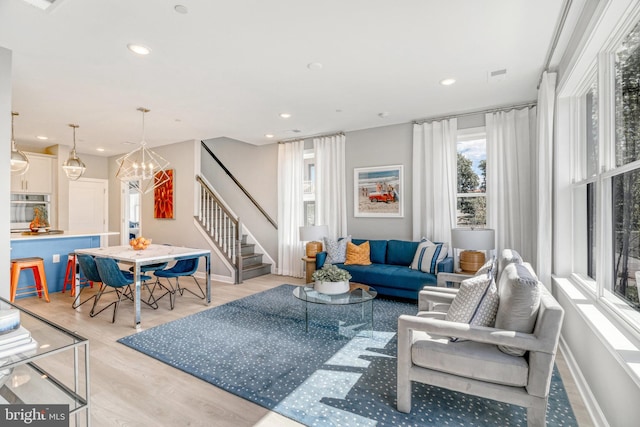 living room featuring light hardwood / wood-style floors and a notable chandelier