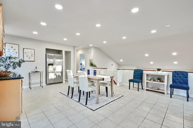 dining space featuring light tile patterned flooring and vaulted ceiling