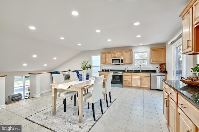 kitchen featuring appliances with stainless steel finishes, sink, lofted ceiling, and a healthy amount of sunlight