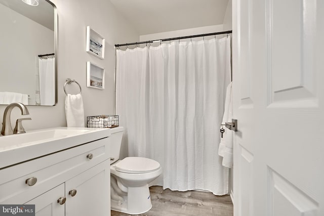 bathroom with hardwood / wood-style floors, vanity, and toilet