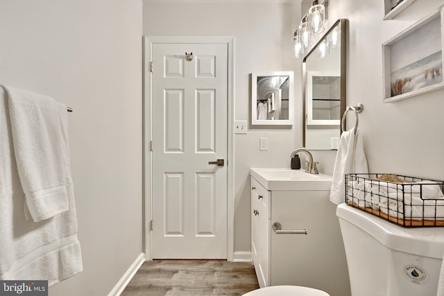 bathroom featuring vanity, hardwood / wood-style flooring, and toilet