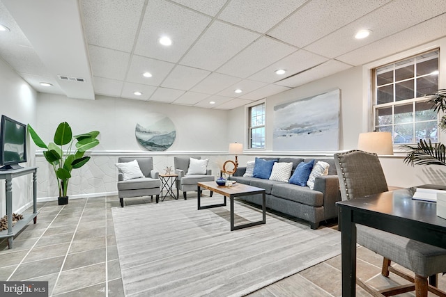 tiled living room featuring a paneled ceiling