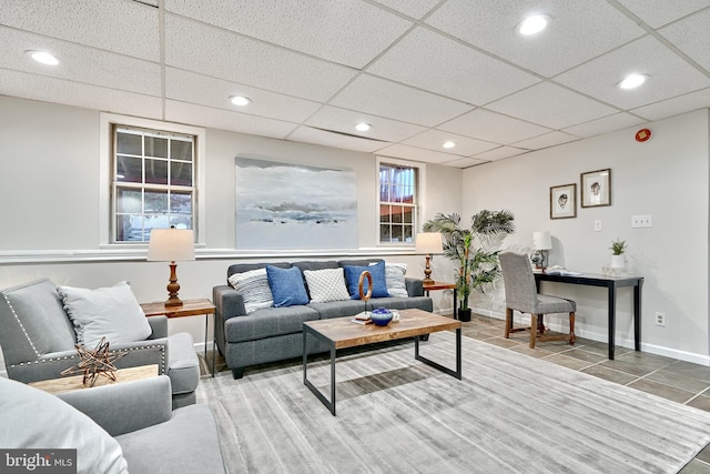 living room with a paneled ceiling and tile patterned floors