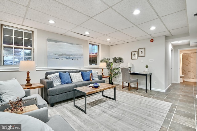 tiled living room featuring a drop ceiling